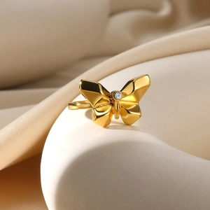 Detail of gold butterfly ring with geometric wings and sparkling center zircon crystal