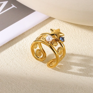 Detailed macro view of multi-layer gold ring with star, pearl and blue gemstone elements