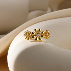 Macro shot of gold-plated daisy ring featuring three flowers with white zircon centers
