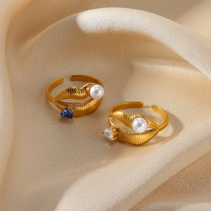 Lip-shaped gold open ring with white pearl and heart-shaped zircon on champagne satin