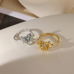 Detail of molten lava textured rings in gold and silver with blue heart gemstone