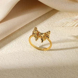 Artistic gold butterfly lava ring detail on beige fabric background with dried flowers