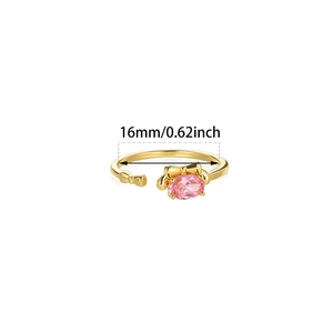 Detail of pink oval gemstone ring with golden bow accents and adjustable open band
