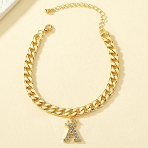 Dettaglio del bracciale a catena dorata con ciondolo a lettera A con strass e corona
