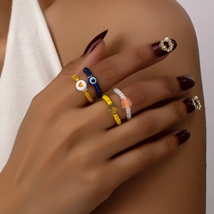 Colorful beaded ring set with heart, star, and evil eye charms on elastic bands