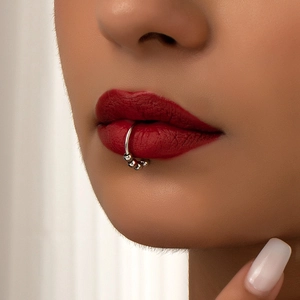 Detail shot of a silver non-piercing lip ring featuring three sliding round metal beads