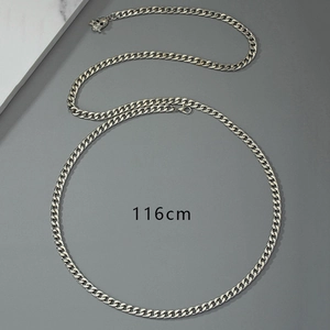 Macro detail of silver punk skull waist chain measuring 116cm on a gray stone surface