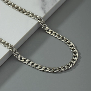 Polished silver skull waist chain with Cuban links and punk tassels on marble background
