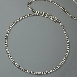 Polished silver cuban link body chain with lobster clasp on a dark grey background