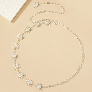 Detailed macro view of silver sun charm waist chain with polished metal links and clasps