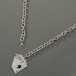 Close-up of silver poker card pendant with sparkling rhinestones and spade royal flush design