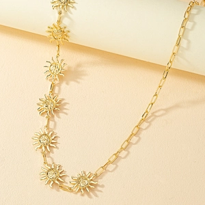 Golden paperclip chain belt featuring vintage sun charms with detailed facial relief