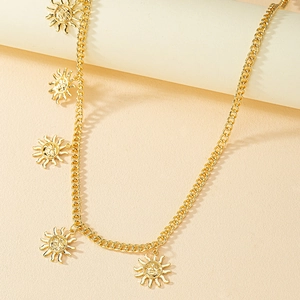 Golden chain belt with sun face pendants displayed on minimalist beige pedestals