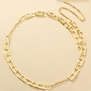 Detail of gold-plated paperclip chain body jewelry set with high-polish metallic finish