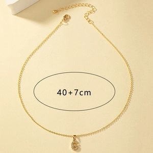 Dettaglio della collana con lettera G dorata, cristalli bianchi e catena di estensione di 7 cm