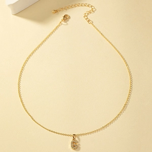 Dettaglio collana dorata lettera G con strass e chiusura a moschettone regolabile