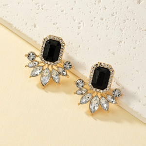 Dettaglio di orecchini vintage dorati con cristalli verdi smeraldo e strass brillanti