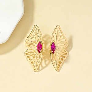 Close-up of golden butterfly wing earrings with hollow design and pink gemstones