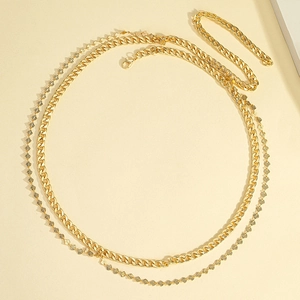 Detailed macro view of dual-layer gold body chain with curb link and leaf charm details