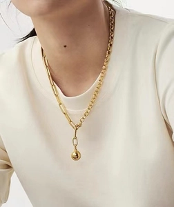 Detail of 18K gold plated mixed chain necklace featuring a polished sphere pendant charm