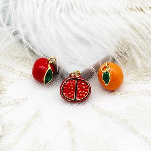 Vue macro de pendentifs fruits colorés plaqués or 18K sur un tissu en dentelle