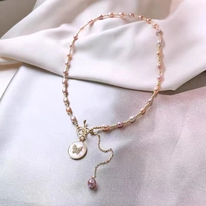 Collar de perlas rosas y moradas con colgante de mariposa en nácar y baño de oro de 18K