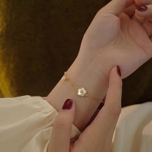 Bracelet fleur plaqué or 18 carats avec nacre blanche et petite perle charmante
