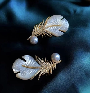 Vue détaillée d'une broche plume plaquée or 18 carats avec nacre et perles fines