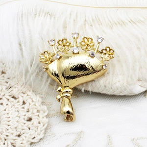 Elegant gold flower bouquet brooch with white zircon stones and feather accents