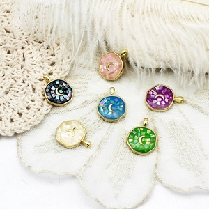 Detailed macro view of octagonal abalone shell pendants with golden crescent moon symbols