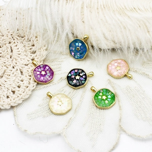 Close-up of geometric abalone shell pendants with golden stars in six assorted colors