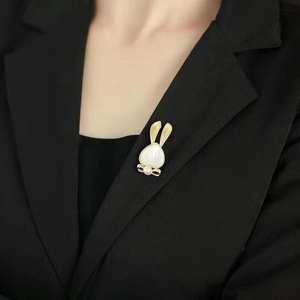 Élégante broche lapin plaquée or 18 carats avec nacre blanche et décoration de nœud en perle