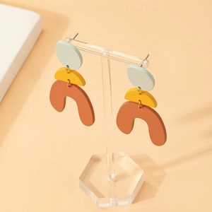 Three-layer geometric dangle earrings in mint green, bright yellow, and ochre clay