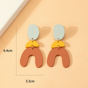 Detail view of geometric drop earrings in matte resin showing 6.4cm height and 3.3cm width