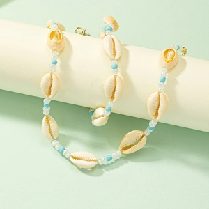 Bohemian seashell beaded necklace with blue beads and cowrie shells on a stand