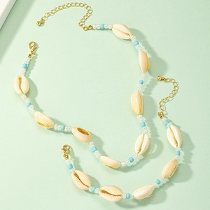 Detailed shot of ocean-style beaded necklace and bracelet set with natural shells