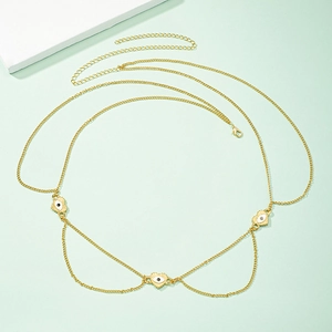 Gold evil eye body chain for women with heart shaped pendants on green background