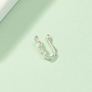Macro shot of silver non-pierced nose ring featuring a detailed serpent scale texture