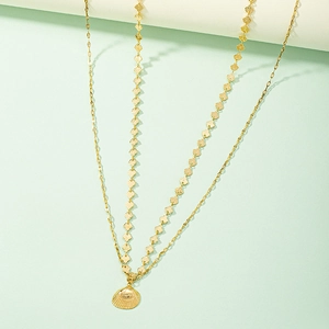 Golden double-layer chain belt with seashell pendant over a mint green background