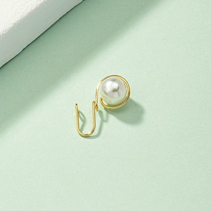 Falso aro de nariz en U dorado minimalista con perla blanca sobre fondo verde claro