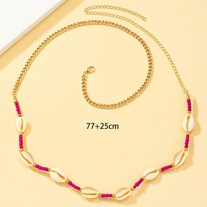 Detailed view of bohemian gold waist chain with pink beads, shells and 25cm extension