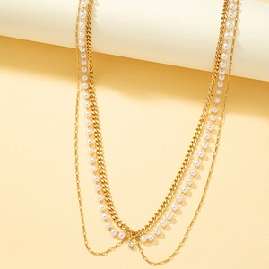 Minimalist gold-tone layered body chain featuring faux pearls and a round crystal pendant