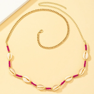 Bohemian seashell waist chain with gold links and vibrant pink beads for beach fashion