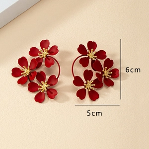 Detail showing oversized burgundy flower earrings with gold stamens and 6cm length