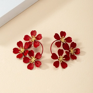 Detailed close-up of matte burgundy floral earrings with textured gold flower stamen