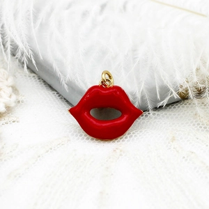 Detailed close-up of a red enamel lip-shaped pendant with a polished 18k gold-plated metal ring