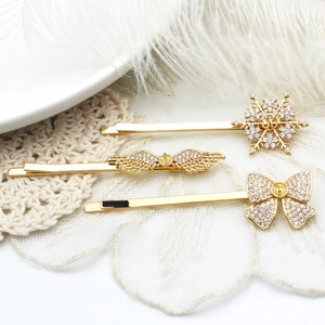 Ensemble de trois barrettes dorées avec flocons, ailes d'ange et nœuds en zircone