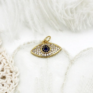 Macro view of gold plated evil eye pendant with micro-pave cubic zirconia stones