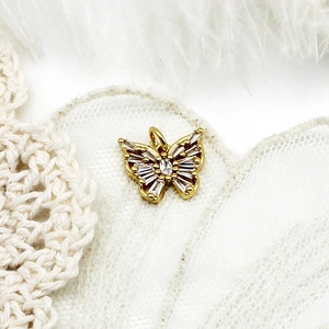 Détail macro du pendentif papillon doré 18K avec incrustations de zircons cubiques