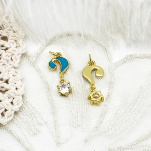 Detail of 18K gold question mark pendant with blue enamel and clear zircon inlay